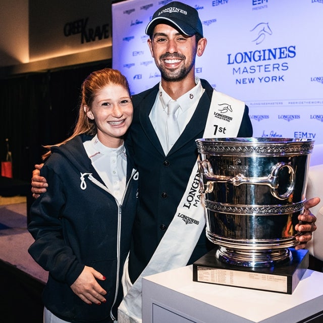 Nayel Nassar of Egypt, winner of the Longines Grand Prix de New York with his girlfriend Jennifer Gates and the trophy at the Longines Masters New York at NYCB Live's Nassau Coliseum on April 28, 2019 in Uniondale, New York.