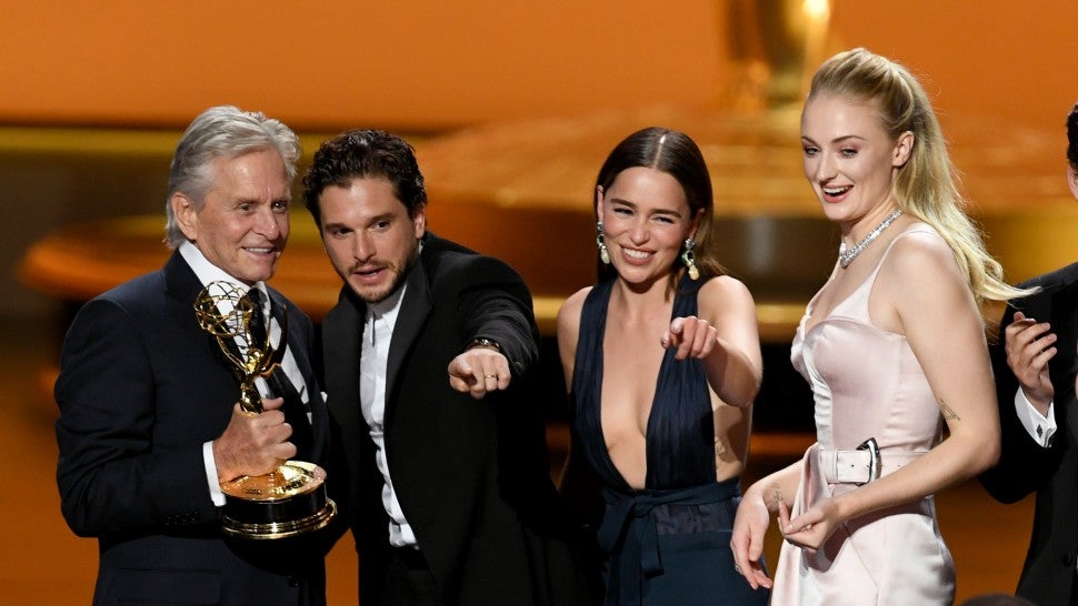 Game of Thrones cast members Kit Harrington, Emilia Clarke and Sophie Turner accept an award from Michael Douglas at the 2019 Emmys.